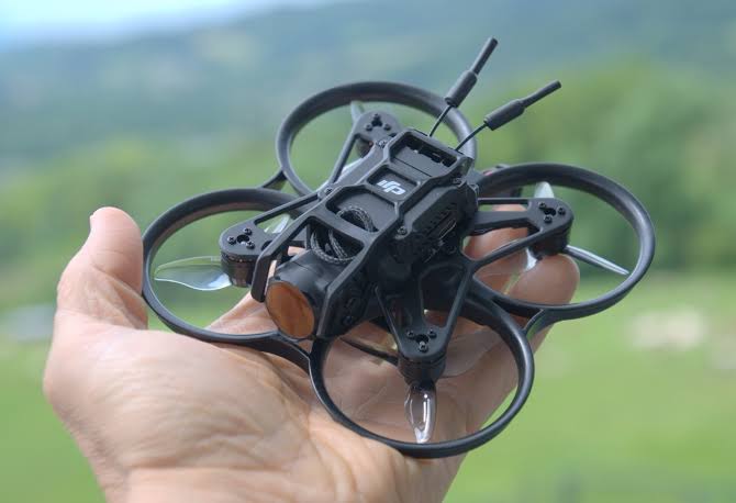 Den lille FPV-drone med propelværn, holdt i én hånd